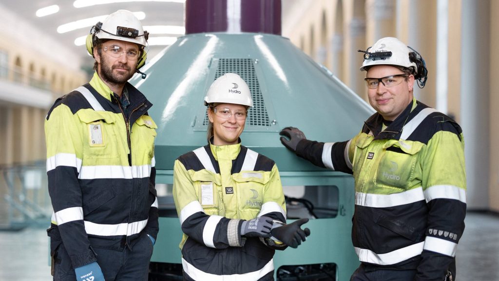 Hydro-ansatte foran en turbin i et vannkraftverk — den fornybare kraften REDUXA produseres på